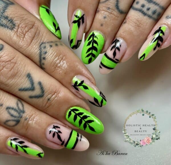Neon green botanical nail art on tattooed hands