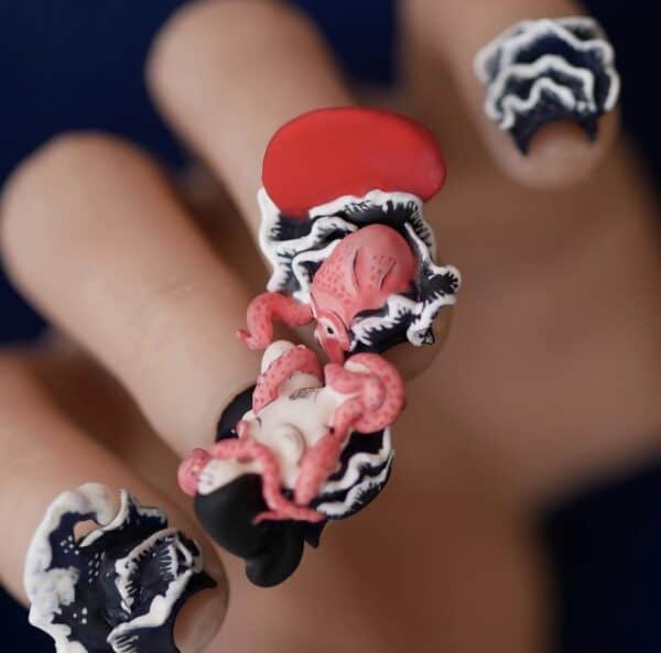 Red octopus nail art on black and white nails