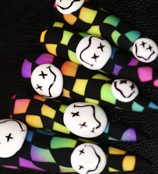 Colourful ghost-patterned Halloween nail art on black background