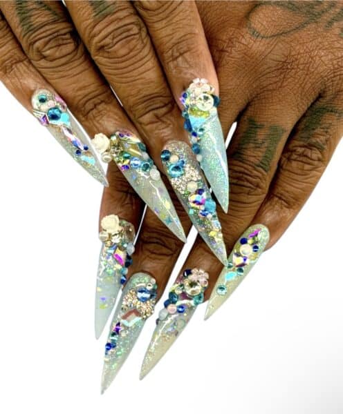 Jeweled aqua stiletto nails with floral embellishments