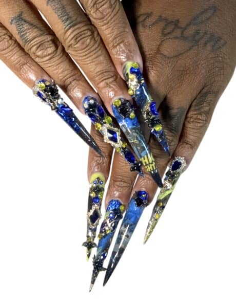 Hands with elaborate blue and yellow stiletto nail art