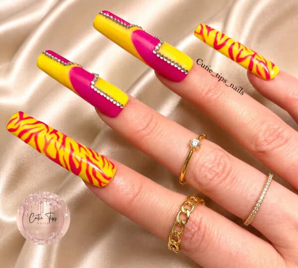 Yellow and pink patterned long nails with rhinestones