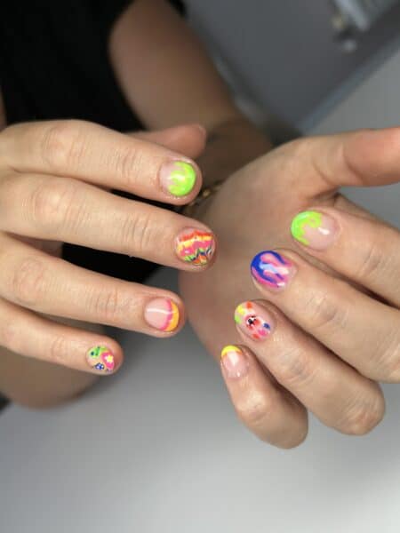 Hands displaying bright neon abstract nail art