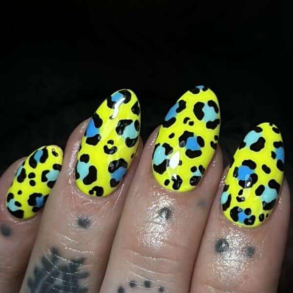 Neon yellow leopard print manicure with turquoise and black spots