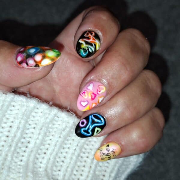Hand displaying colourful, abstract nail art designs