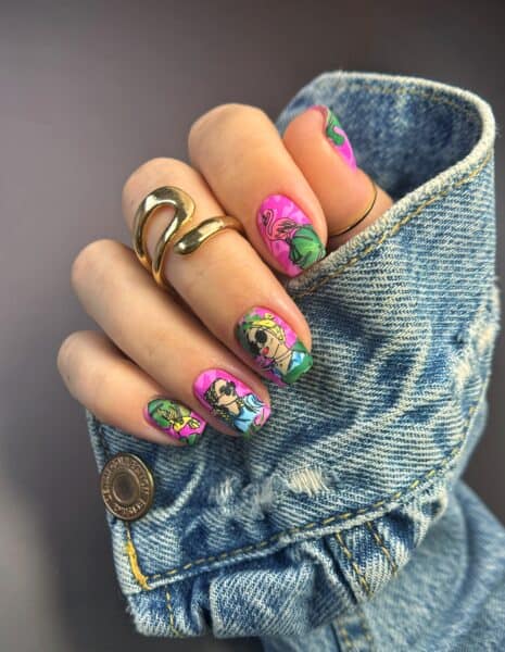Hand with colourful cartoon nail art on denim