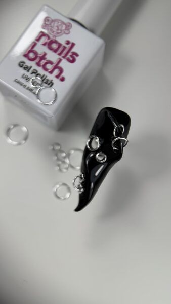 Pink plastic fasteners and metal rings on white surface