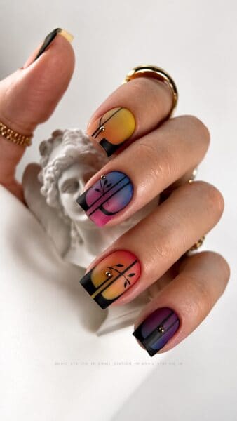 Multicoloured gradient nails with black geometric floral designs