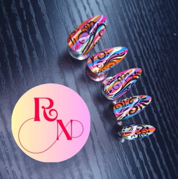 Colourful abstract patterned false nails on dark textured background