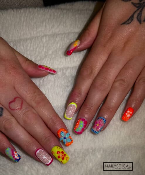 Colourful floral and polka dot nail art on hands