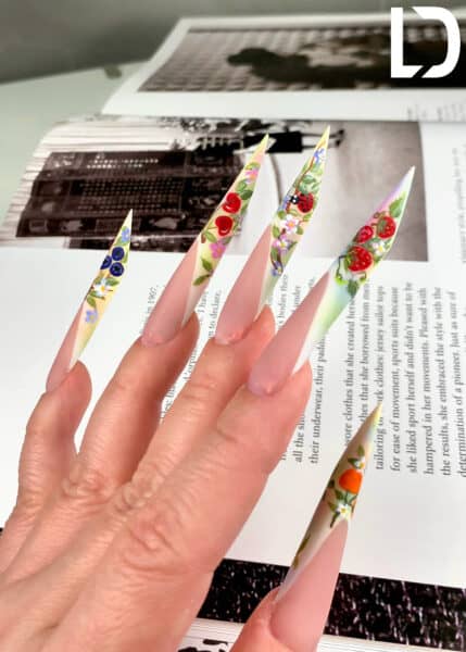 Hand with long floral fruit stiletto nail art