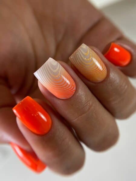 Orange and nude geometric striped manicure close-up