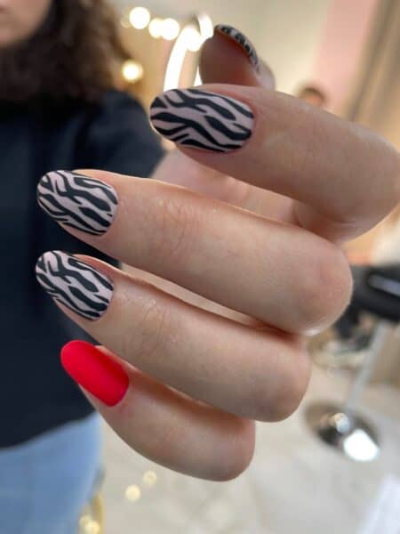Close-up of zebra-print and red manicured fingernails