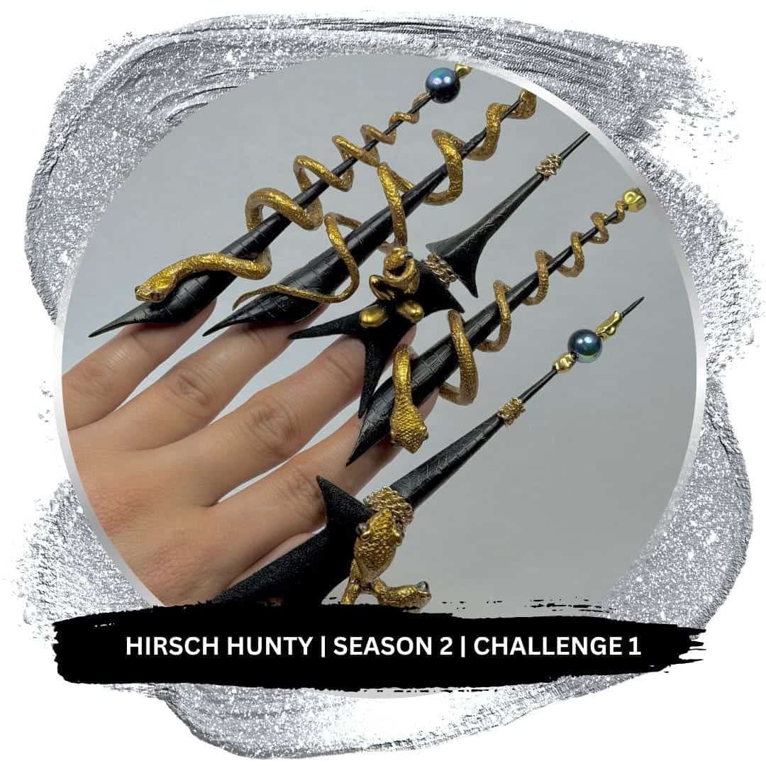 Black stiletto nails with gold serpents and spikes