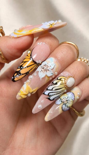 Butterfly and floral stiletto nails with pearl embellishments