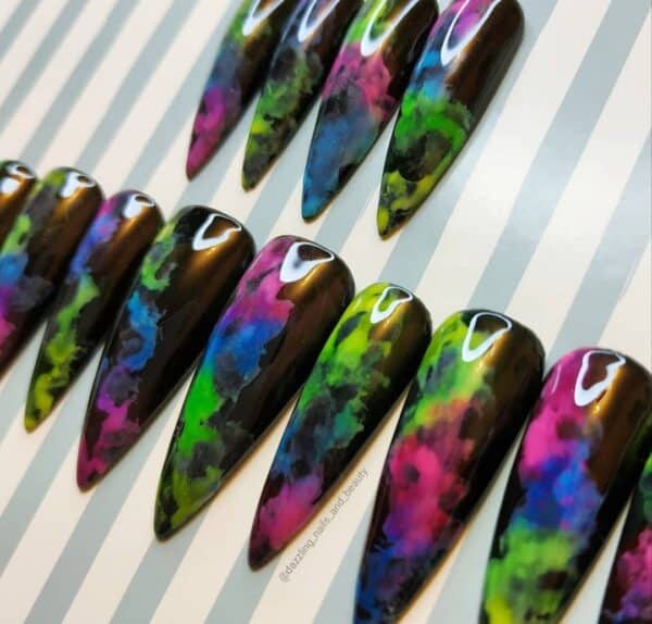Glossy black stiletto nails with vivid neon marble patterns