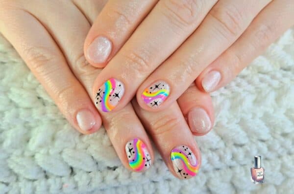 Hands with colourful rainbow swirl and sparkle nail art