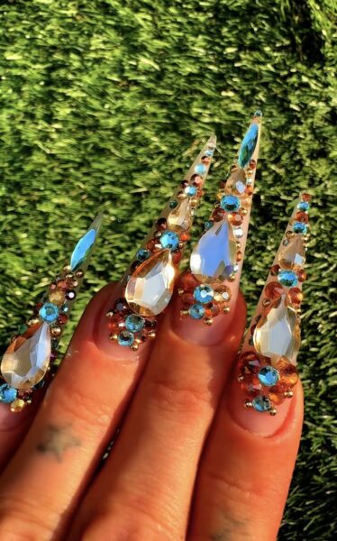 Long stiletto nails decorated with colourful rhinestones