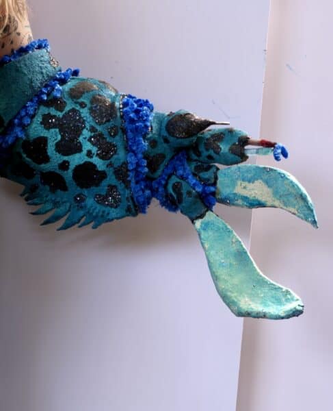 Turquoise leopard-print costume with blue fringe and curved appendage