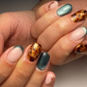 Green and tortoiseshell patterned manicure on hands