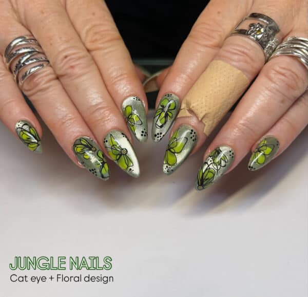 Green floral cat eye nail art on manicured hands