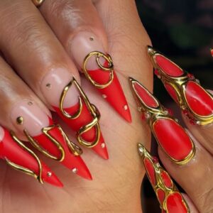 Long red stiletto nails with gold sculpted detailing