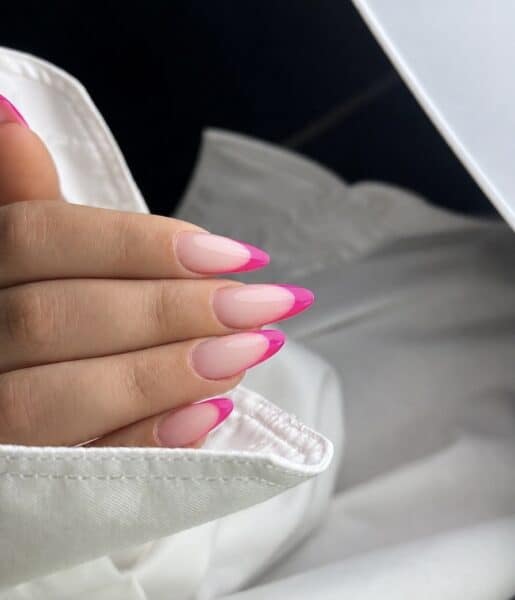 Hand with glossy pink French tip almond nails