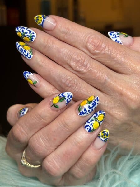 Hands with blue, white and yellow floral nail art