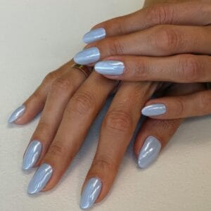 Hands with pearlescent light blue manicured nails and gold rings
