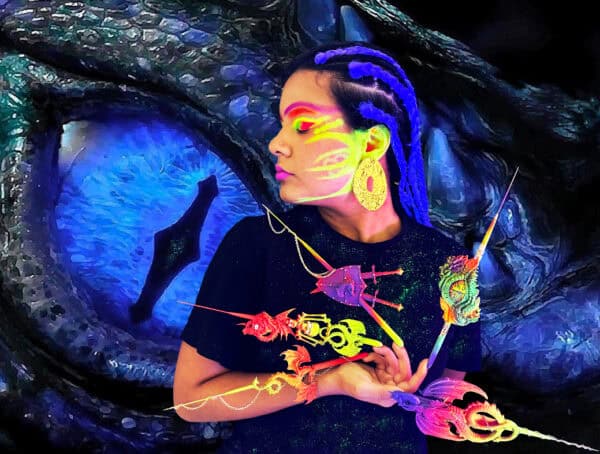Woman with neon makeup holding colourful fantasy creatures