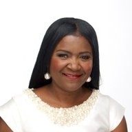 Smiling woman in white blouse with pearl earrings