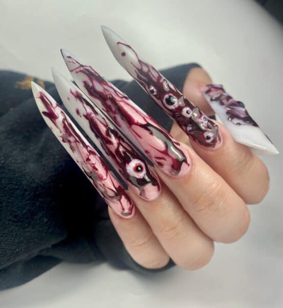 Blood-red stiletto nails with raised eyeball decorations