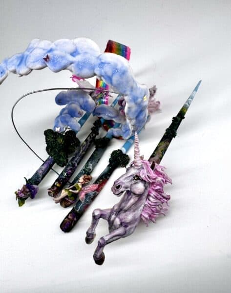 Handcrafted unicorn and rainbow-themed decorative wands with cloud arch