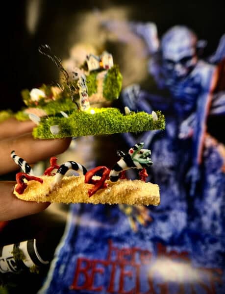 Hands holding miniature swamp scene with frogs and alligator