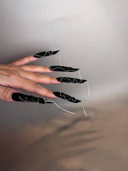 Hand with black embellished stiletto acrylic nails