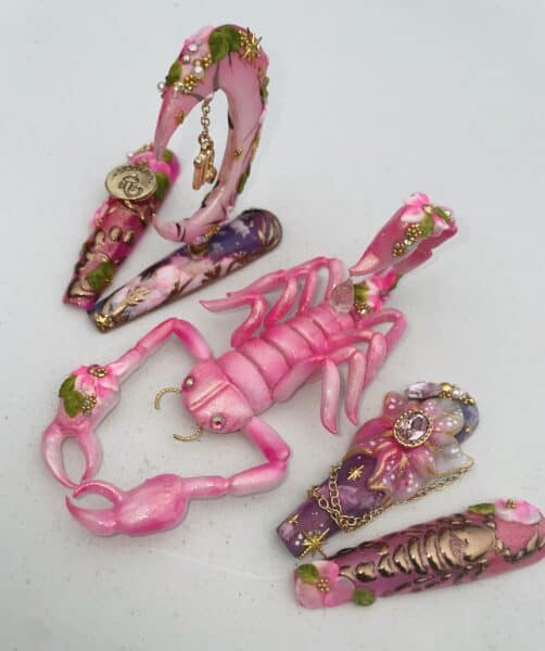 Decorated pink fantasy claw jewellery pieces with gold charms