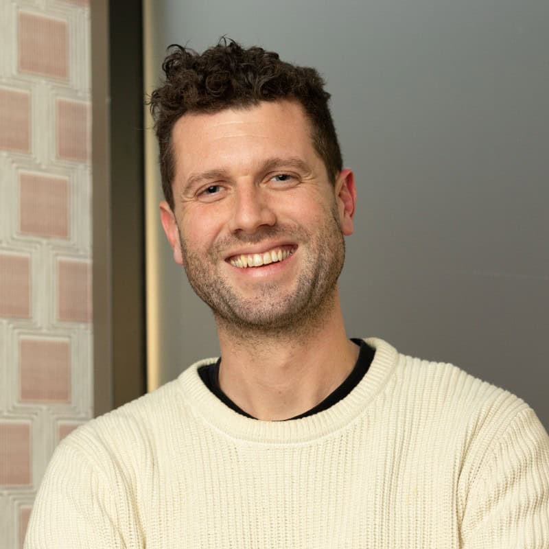 Smiling man in a cream knitted jumper