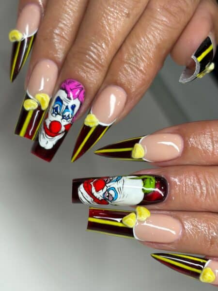 Long stiletto nails with sinister clown-themed nail art