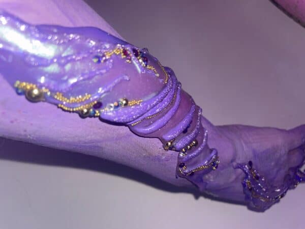 Purple glitter acrylic nails with gold beads and rhinestones