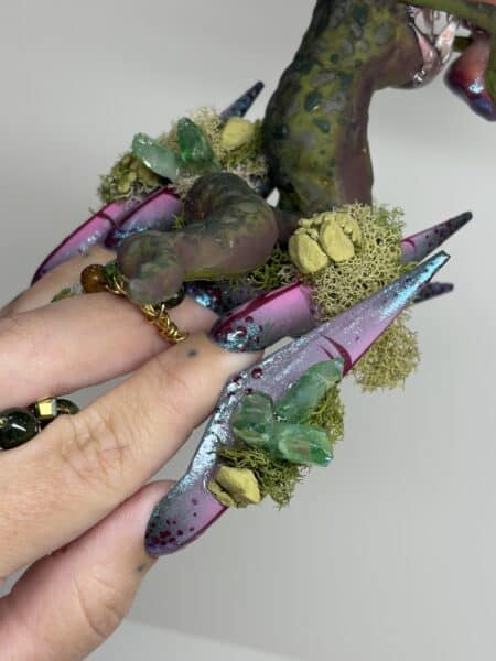 Elaborate fantasy nails with crystals, moss, and spotted green extensions