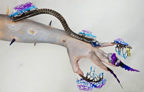 Hand with elaborate purple and blue sculptural nail art