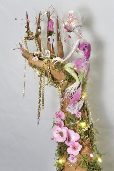 Pink fairy beside an enchanted tree sculpture