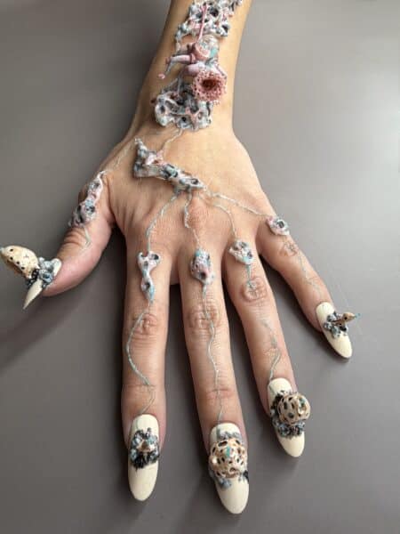 Hands with elaborate abstract nail art and long extensions