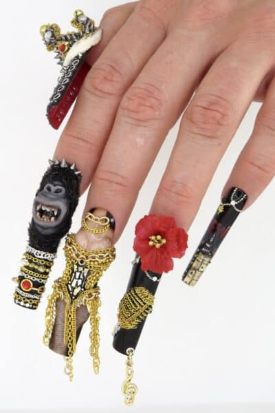 Extravagant black stiletto nails with chains, spikes and flowers