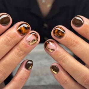 Glossy tortoiseshell nail art with gold foil accents