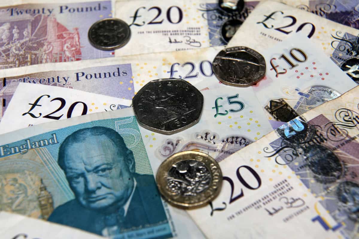 British pound banknotes and coins scattered together