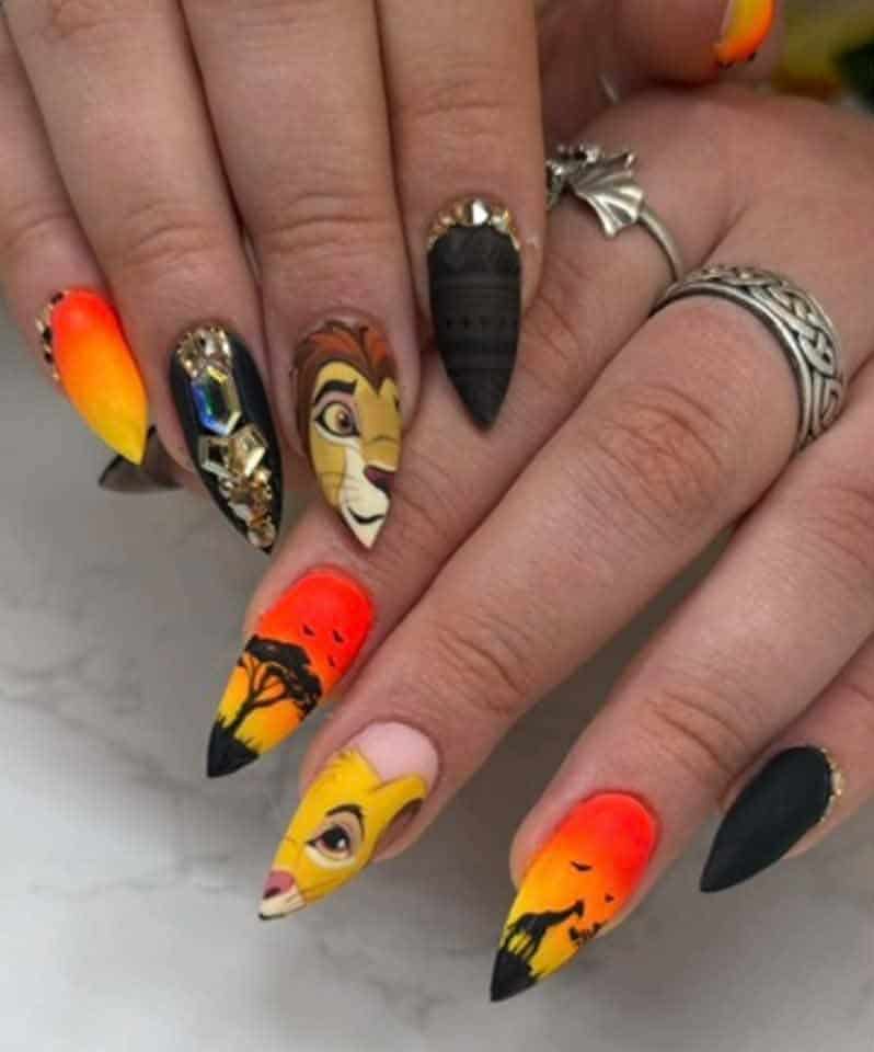 Lion King-inspired nail art with sunset silhouettes and jewels