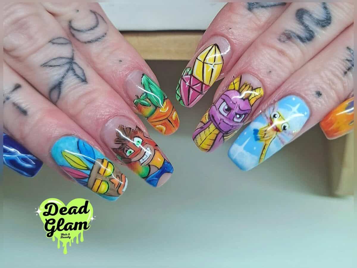 Colourful cartoon-themed nail art on tattooed hands