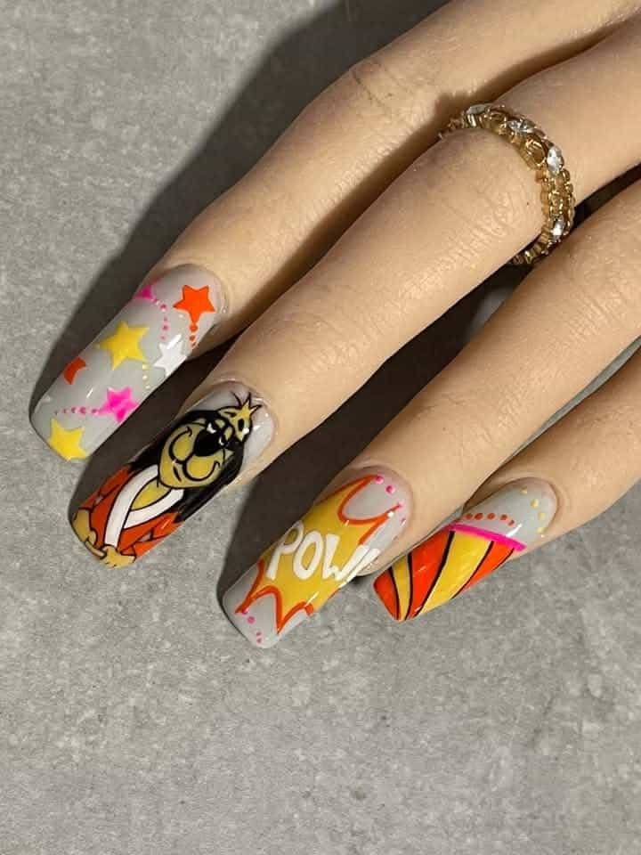 Hand with colourful comic-style nail art and gold ring