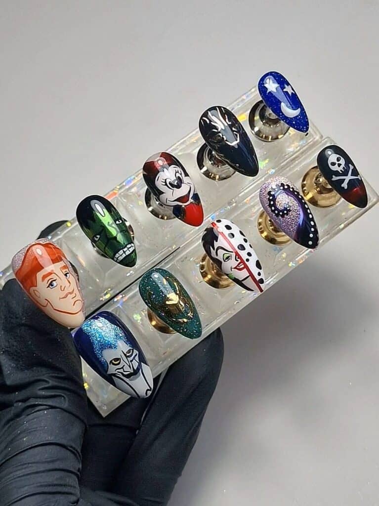 Hand-painted character nail art displayed on a clear stand